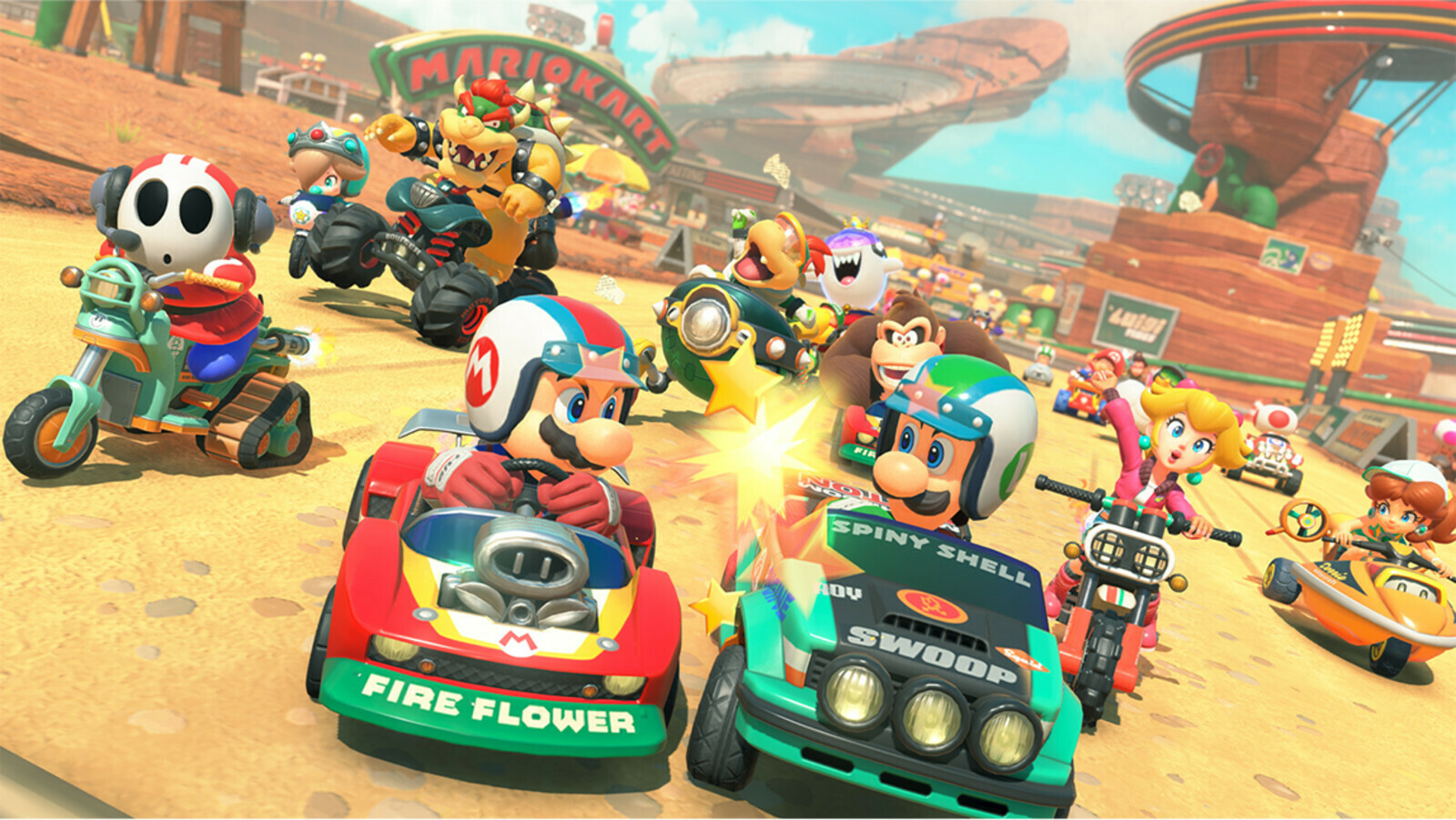 Une meute de pilotes au coude à coude devant une arche Mario Kart